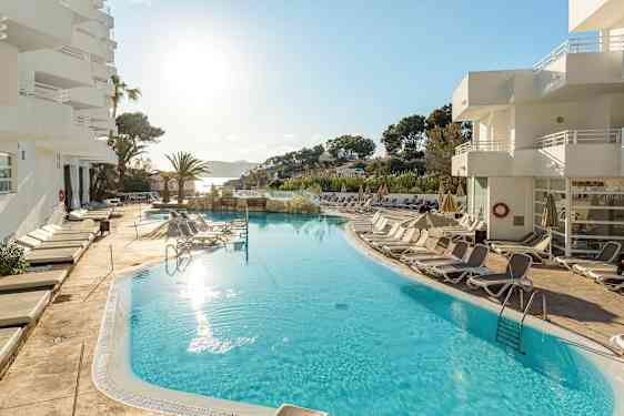 Utendørs basseng med solsenger rundt, ved et hotell i solfylt vær. (AI-generert tekst)