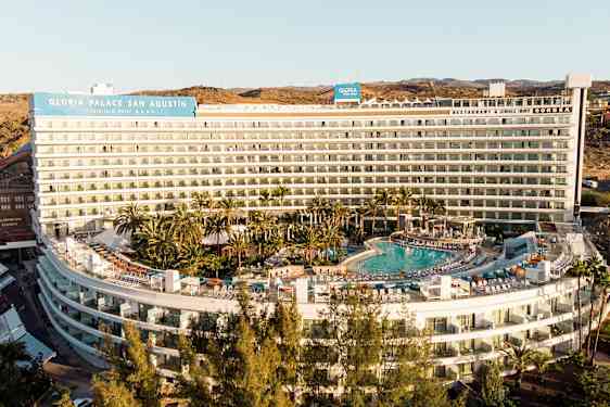 Hotellbygning med basseng og omkringliggende grøntareal. (AI-generert tekst)