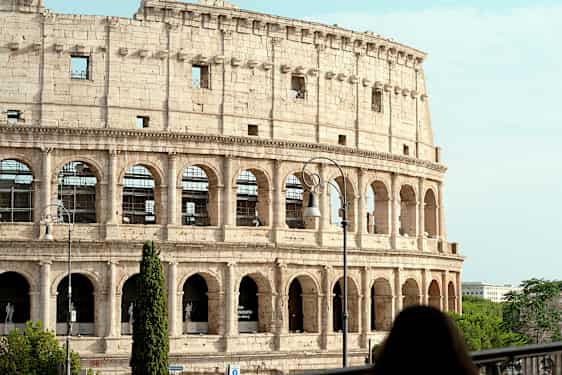 Bilde av Colosseum i Roma, Italia, med en kvinne i forgrunnen. (AI-generert tekst)