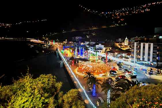 By ved sjøen om natten med belysning og dekorasjoner. (AI-generert tekst)