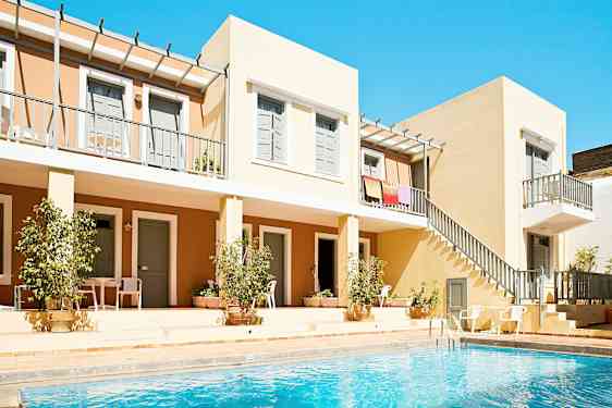 Bilde av en bygning med leilighetsbalkonger og et basseng i forgrunnen. (AI-generert tekst)