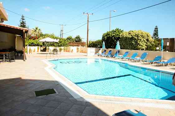 Utendørsbasseng med solstoler og parasoller ved siden av en terrasse. (AI-generert tekst)