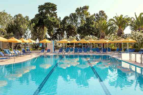 Utendørsbasseng med blått vann, omgitt av solsenger, parasoller og grønne trær. (AI-generert tekst)