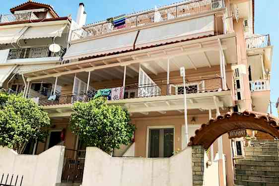 Et flerfamiliehus med flere balkonger og klær som henger til tørk. (AI-generert tekst)