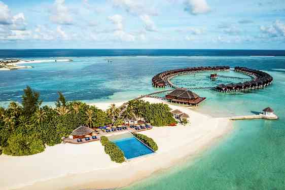 Luftfoto av en tropisk kyst med sandstrand, hav og overnattingsbungalower. (AI-generert tekst)