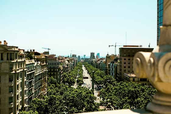 Utsikt over en bygategate omkranset av trær og omgitt av bygninger, tatt fra et høyere punkt. (AI-generert tekst)