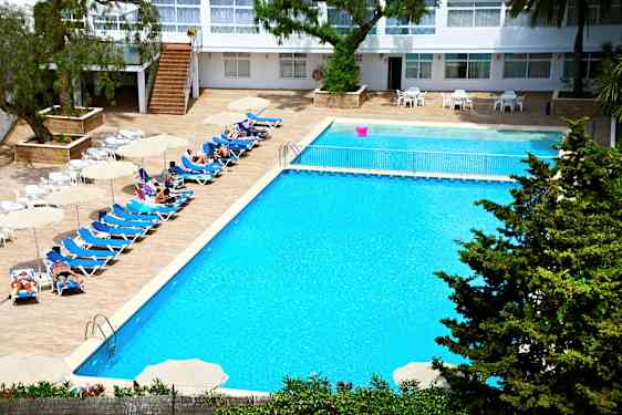 Et hotellbasseng med solsenger, parasoller og mennesker som nyter solen. (AI-generert tekst)