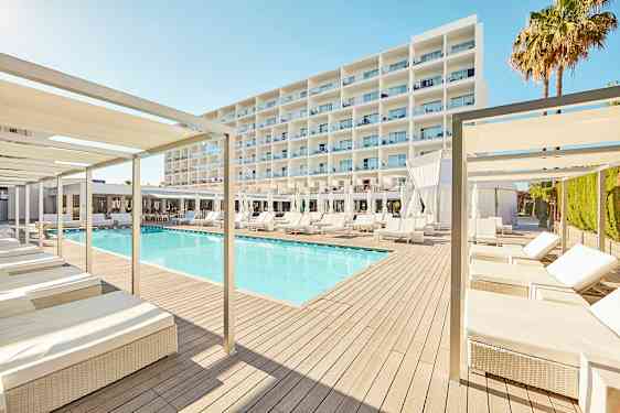 Et moderne hotellmiljø med et basseng omgitt av solsenger og parasoller, med en stor hvit bygning i bakgrunnen. (AI-generert tekst)