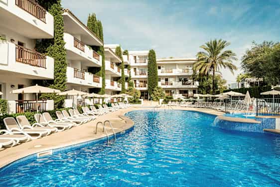 Bilde av et utendørs basseng omgitt av solsenger og parasoller, med et hotell i bakgrunnen. (AI-generert tekst)