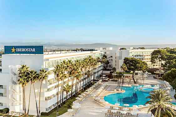 Et moderne hotell omgitt av palmer med et stort, klart blått basseng. (AI-generert tekst)