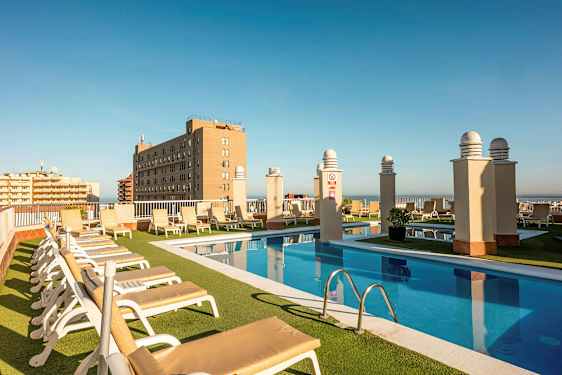 Bilde av en takterrasse med basseng, solsenger og utsikt over omkringliggende bygninger. (AI-generert tekst)