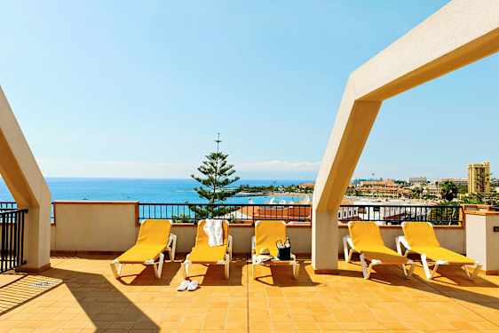 Terrasse med solsenger og havutsikt. (AI-generert tekst)