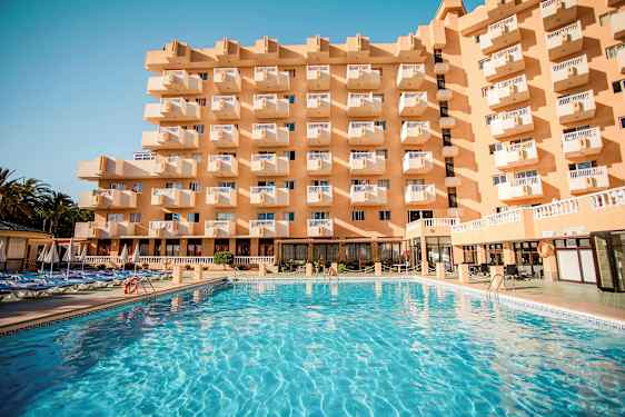 Bygning med flere balkonger og et stort basseng foran. (AI-generert tekst)