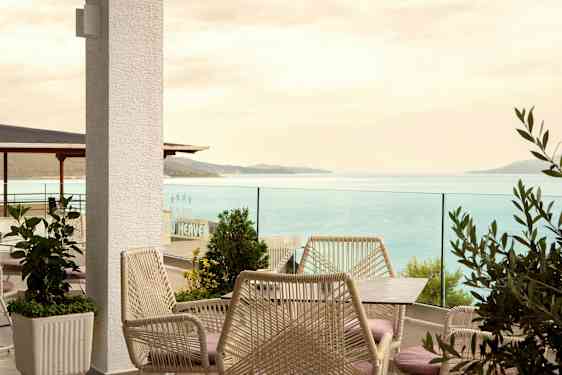 En terrasse med utemøbler og utsikt over havet. (AI-generert tekst)