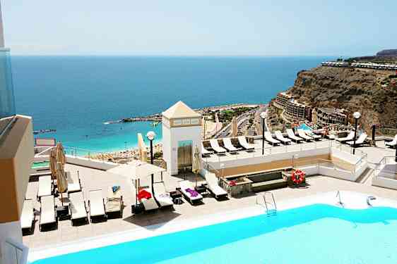 Bassengområde med utsikt over havet og en strand. (AI-generert tekst)