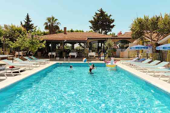 Utendørs svømmebasseng med mennesker som svømmer på et feriested. (AI-generert tekst)