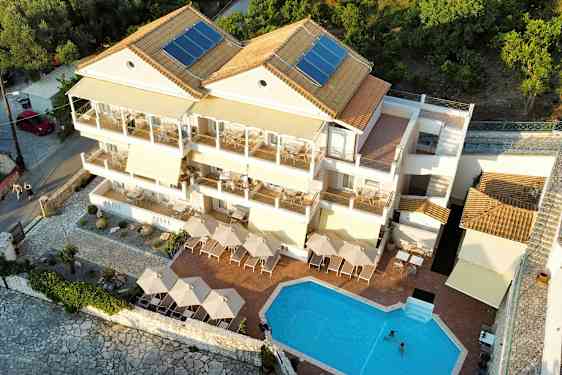 Utsikt over en leilighetsbygning med basseng og terrasse. (AI-generert tekst)