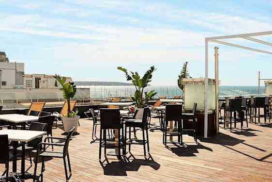 Terrasse med utemøbler og utsikt over havet. (AI-generert tekst)