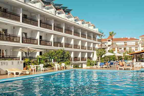 Hotellbygning ved et svømmebasseng. (AI-generert tekst)