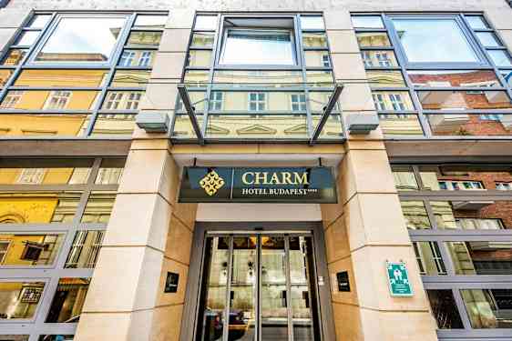 Inngang til et hotell med skiltet "Charm Hotel Budapest". (AI-generert tekst)