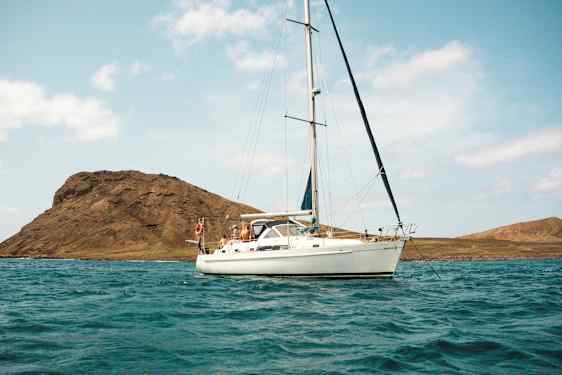 Seilbåt på vann med fjell i bakgrunnen. (AI-generert tekst)