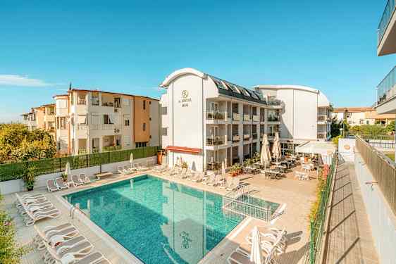 En bygning med hotelltjenester ved et utendørsbasseng. (AI-generert tekst)