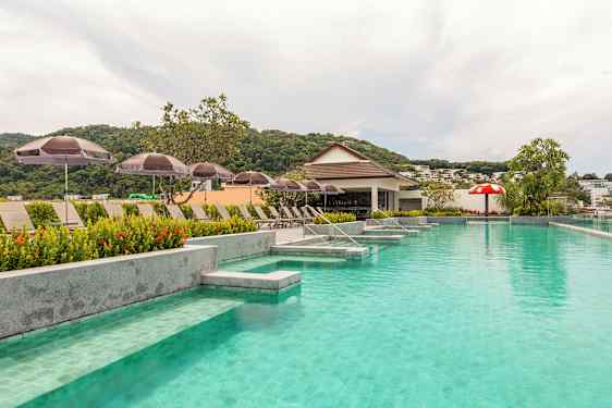 Bassengområde med solsenger og parasoller og en liten bar i bakgrunnen. (AI-generert tekst)