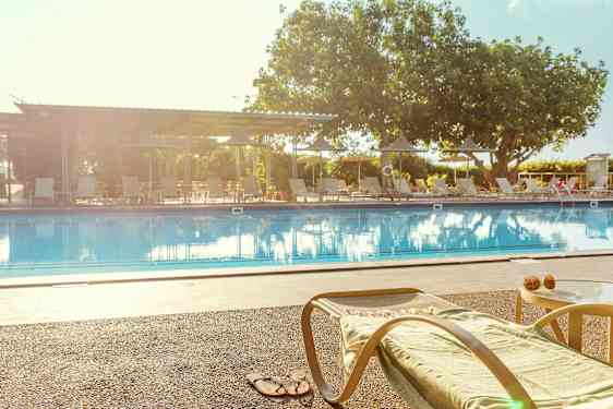 En solseng og et bord ved kanten av et basseng. (AI-generert tekst)