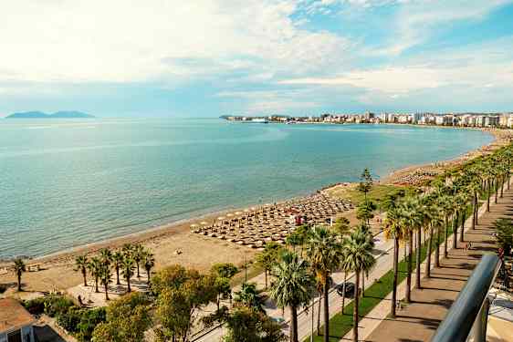 Strand med parasoller og havet i bakgrunnen. (AI-generert tekst)