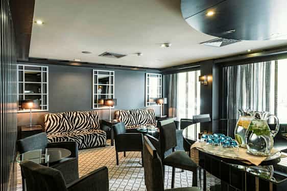 Et rom med møbler med sebramønster og glassbord. (AI-generert tekst)