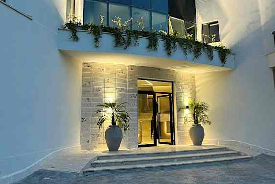 Inngang med to potter, trapper og belysning om kvelden. (AI-generert tekst)