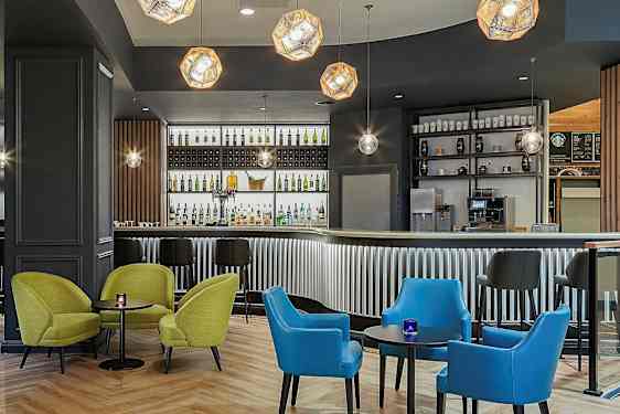 En moderne bar med fargerike sittemøbler og belysning. (AI-generert tekst)