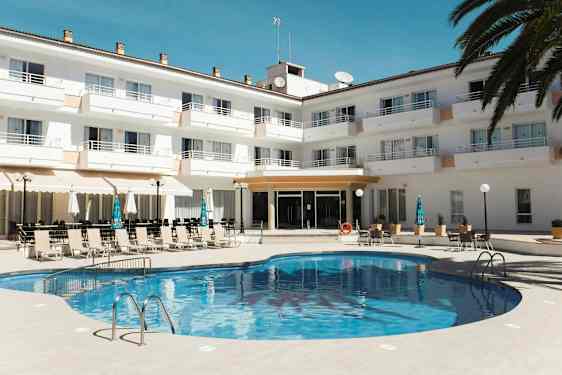 Et basseng foran et hotellkompleks med solsenger og parasoller. (AI-generert tekst)