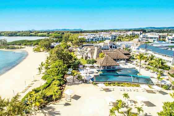 Luftfoto av en resort ved en sandstrand med palmer og et basseng. (AI-generert tekst)