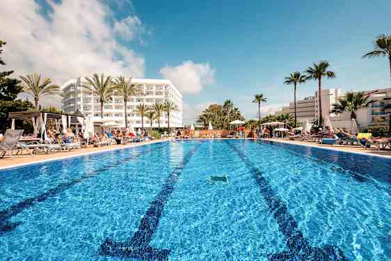 Utendørsbasseng ved hotell med solsenger og palmer. (AI-generert tekst)