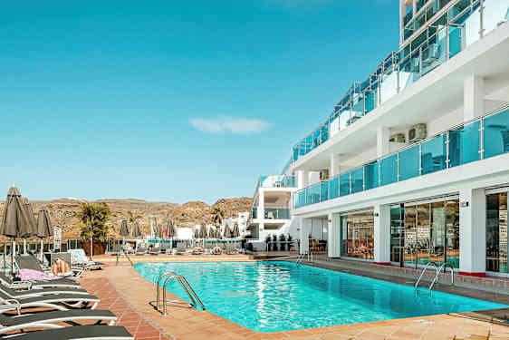 Bassengområde ved hotell med solsenger og parasoller. (AI-generert tekst)