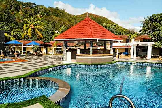 Svømmebasseng med et bassengbarområde og omkringliggende tropiske trær. (AI-generert tekst)