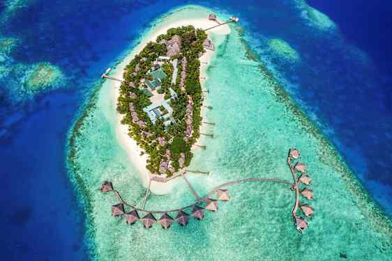 Luftfoto av en tropisk øy med bygninger omgitt av turkist vann. (AI-generert tekst)