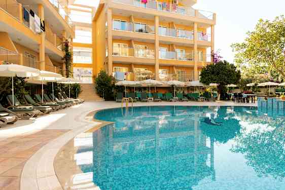 Bygning med balkonger og et basseng i forgrunnen. (AI-generert tekst)