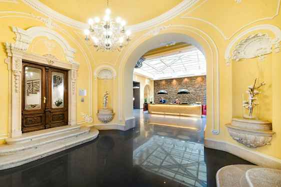 Inngangsområde med klassiske arkitektoniske detaljer og resepsjon i en lys atmosfære. (AI-generert tekst)