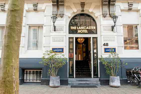Inngang til et hotell med skiltet 'The Lancaster Hotel' over døren. (AI-generert tekst)