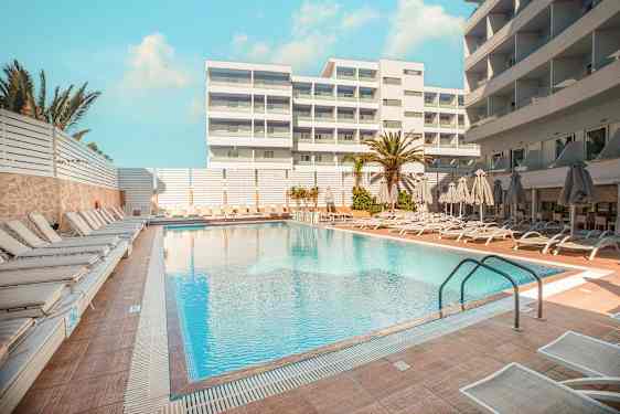 Hotellbasseng med solsenger og parasoller på omkringliggende terrasse. (AI-generert tekst)