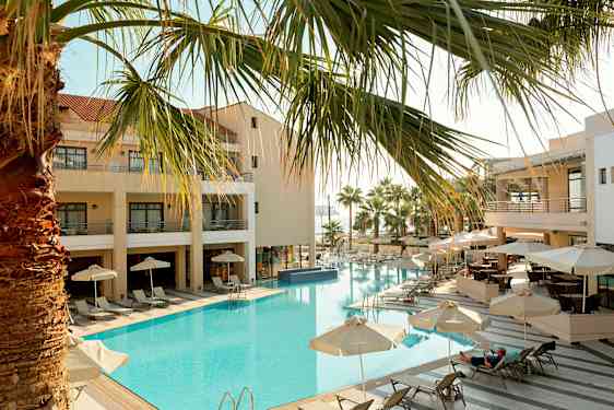 Hotell med utendørsbasseng, solsenger og parasoller. (AI-generert tekst)