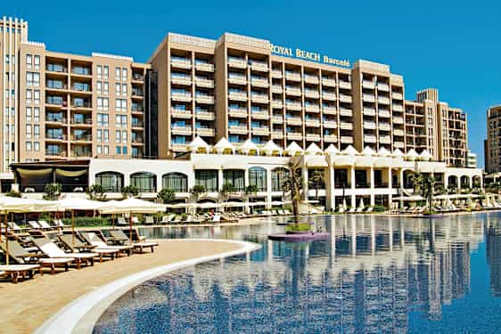 Et hotell med flere etasjer ved et stort basseng omgitt av solsenger og parasoller. (AI-generert tekst)