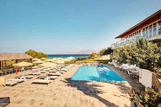 Et basseng med solsenger og parasoller på en terrasse med utsikt over havet. (AI-generert tekst)