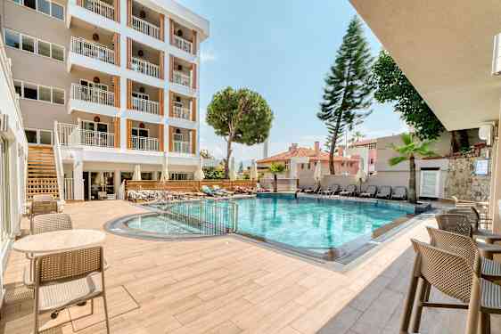 Hotellets utendørsbasseng med sittemøbler og solsenger. (AI-generert tekst)