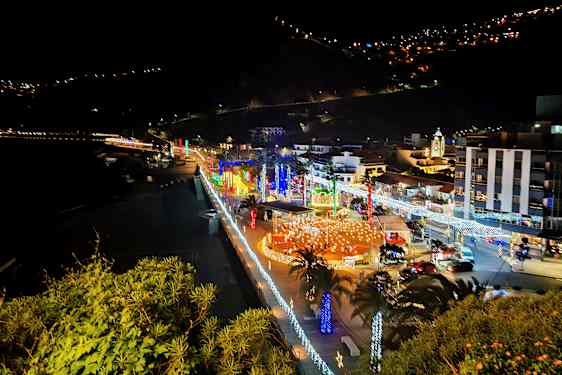 By ved sjøen om natten med belysning og dekorasjoner. (AI-generert tekst)