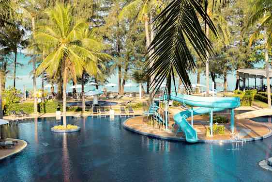 Et utendørs svømmebasseng med en blå vannsklie og palmer rundt. (AI-generert tekst)