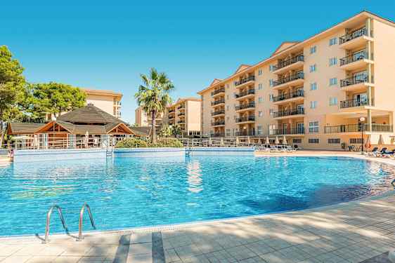 Bilde av et hotellbasseng med omkringliggende bygninger og en palme. (AI-generert tekst)