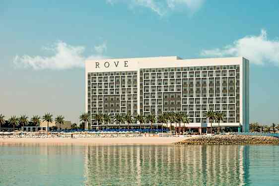 Et hotell ved en strand med palmer. (AI-generert tekst)